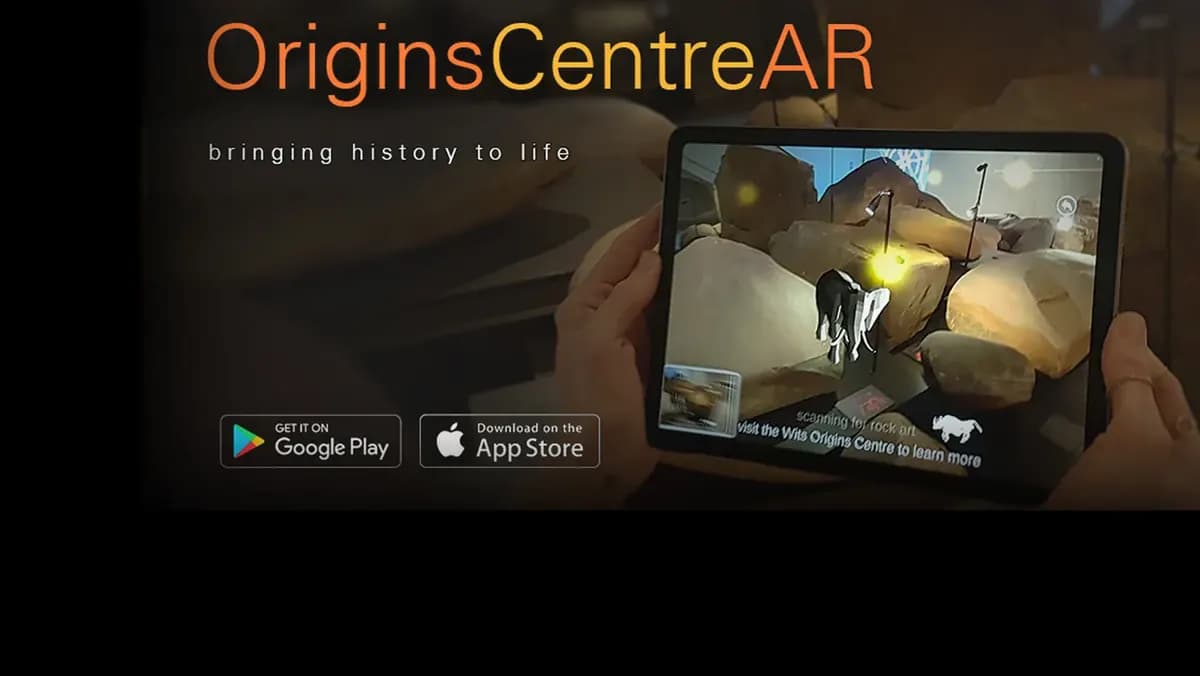 Hands hold a tablet running OriginsCentreAR in front of a rock, with App Store and Google Play badges.
